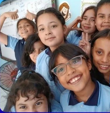 Grupo de alumnas sonriendo en su aula